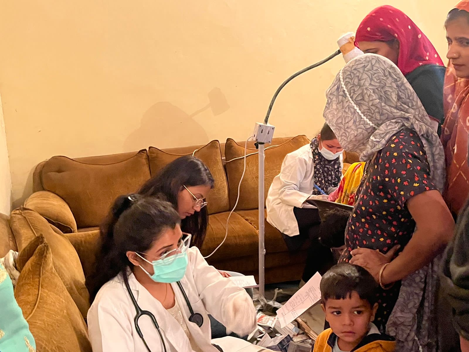 Doctor providing care to women and children in a remote community home visit